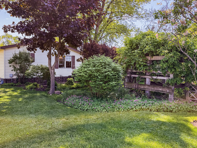 38569 North Sheridan Road, Unit 390 Beach Park, IL 60099 - Photo 18 of 28 a backyard of a house with lots of green space