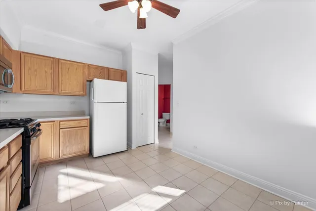 a kitchen with a refrigerator a stove top oven and cabinets