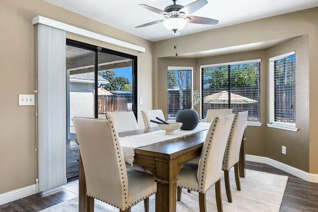 a kitchen with a dining table chairs and stainless steel appliances