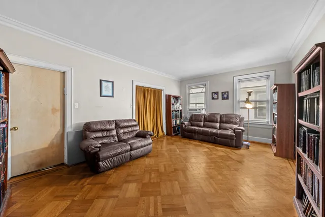 a living room with furniture and a book shelf