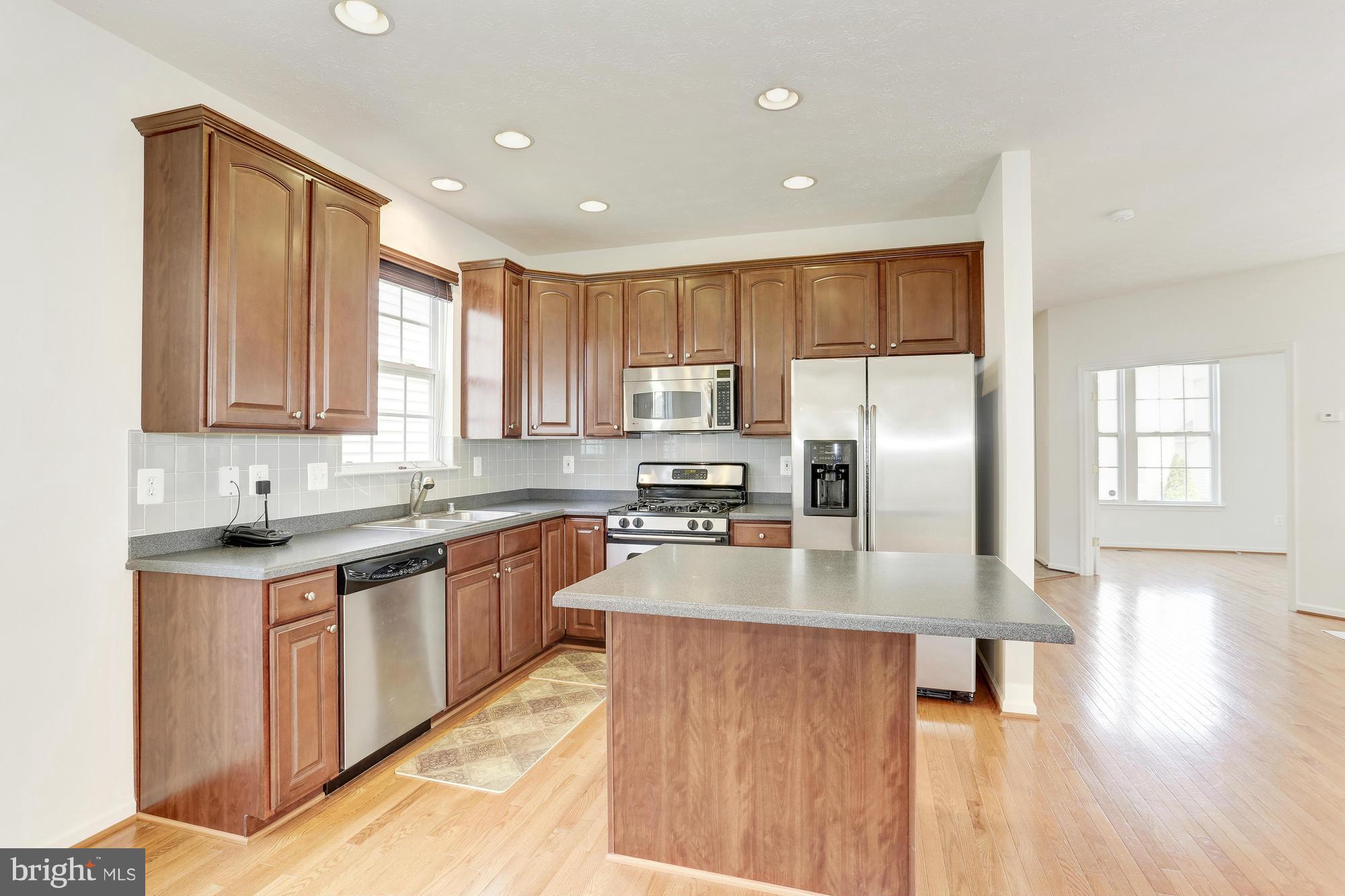 9637 Biggs Road Middle River, MD 21220 - Photo 13 of 30 a large kitchen with stainless steel appliances granite countertop a stove a sink dishwasher and a refrigerator