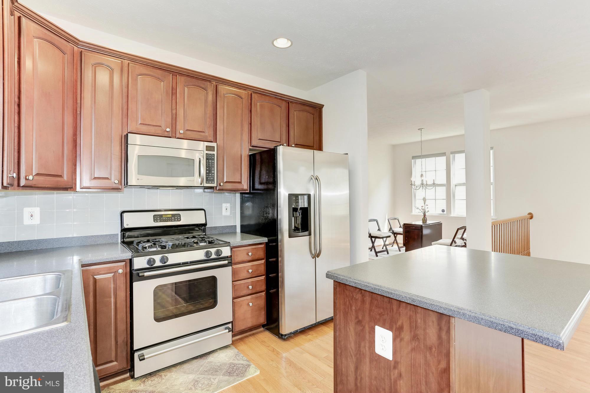 9637 Biggs Road Middle River, MD 21220 - Photo 15 of 30 a kitchen with stainless steel appliances a stove a sink a microwave and cabinets