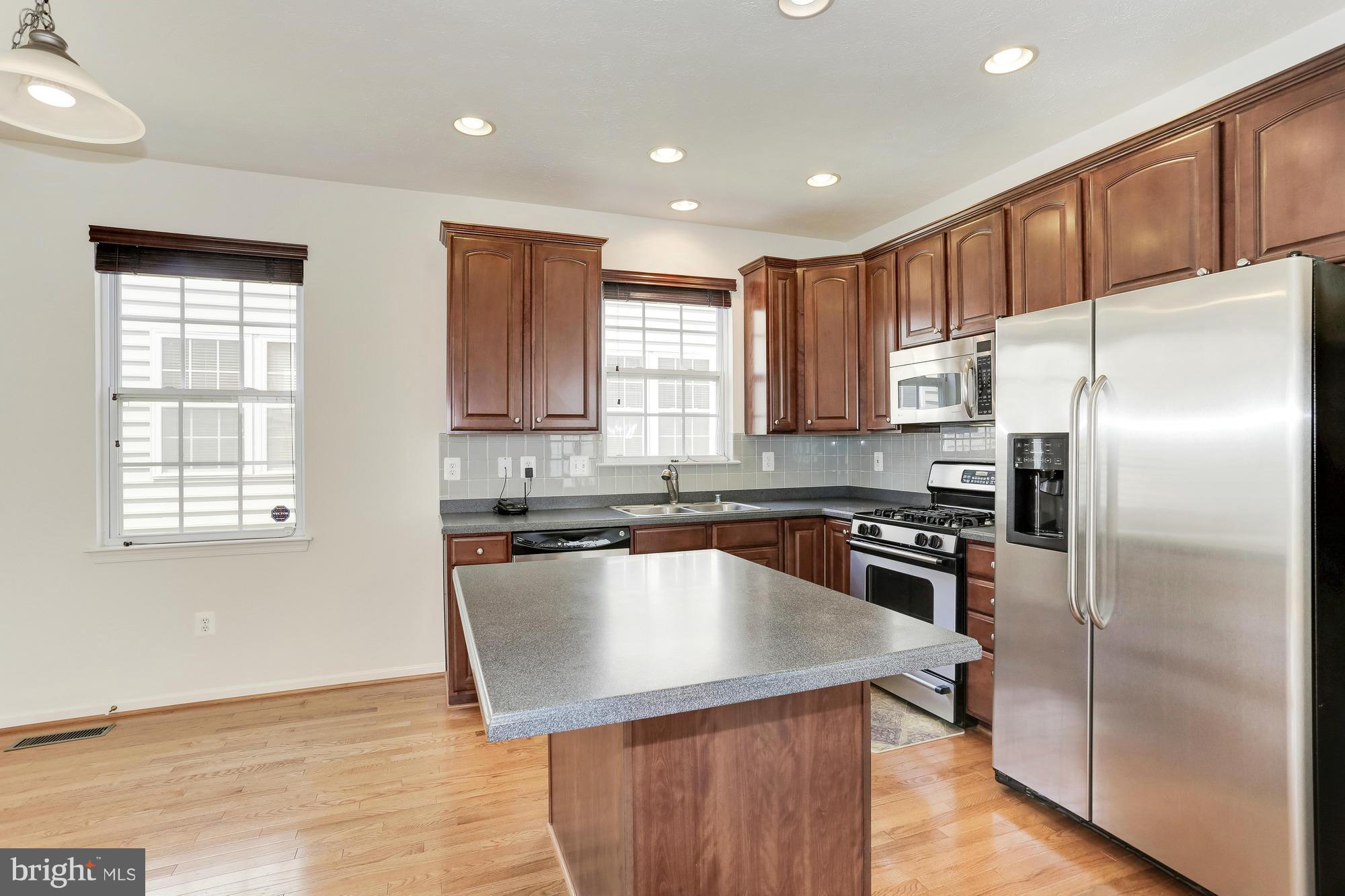 9637 Biggs Road Middle River, MD 21220 - Photo 16 of 30 a kitchen with kitchen island a counter top space cabinets and stainless steel appliances
