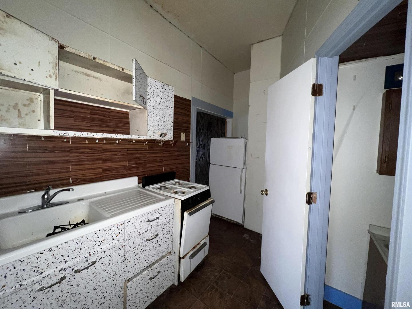 406 South University Avenue Carbondale, IL 62901 - Photo 18 of 36 a kitchen with granite countertop a refrigerator a sink and white cabinets