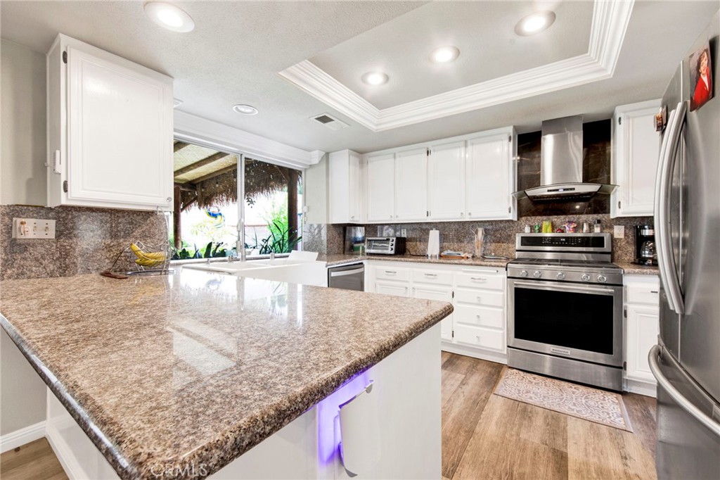 970 West Norwood Street Rialto, CA 92377 - Photo 5 of 17 a kitchen with stainless steel appliances granite countertop a stove a sink and a microwave