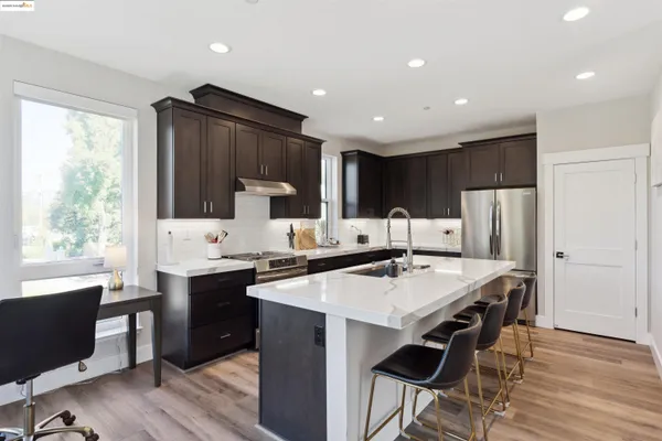 a kitchen with granite countertop a sink stove and refrigerator