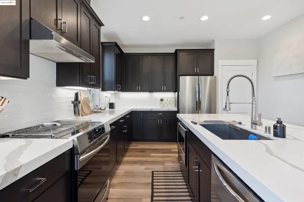 a kitchen with stainless steel appliances a sink stove and refrigerator