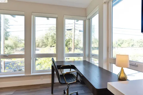 a view of a workspace with wooden floor and a window