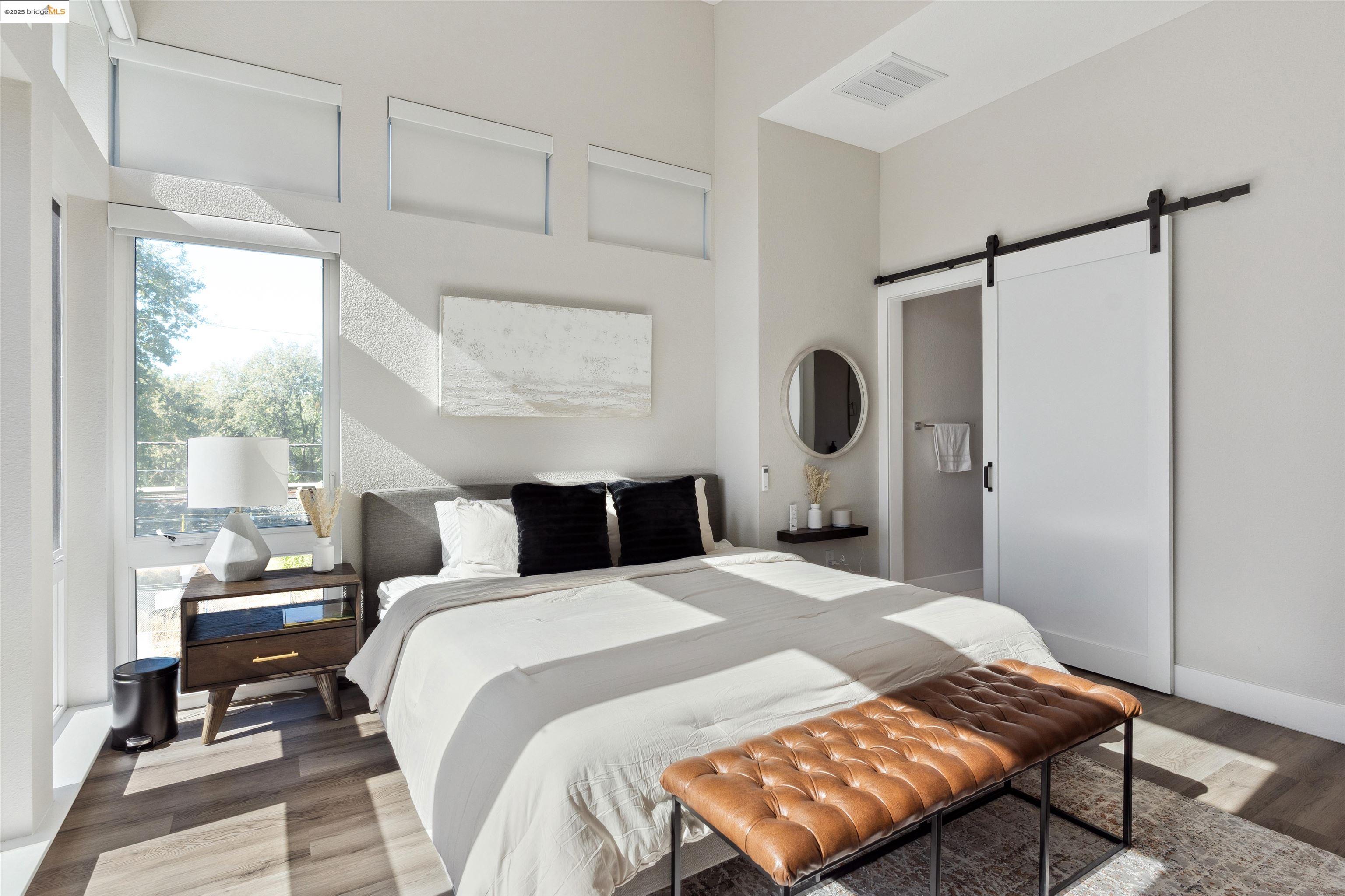 2640 Jones Road, Unit A Walnut Creek, CA 94597 - Photo 28 of 43 Bedroom with a barn door, wood finished floors, and ensuite bath