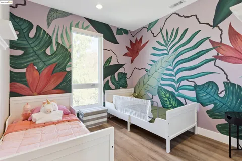 a living room with chairs and paintings on the wall with a large window