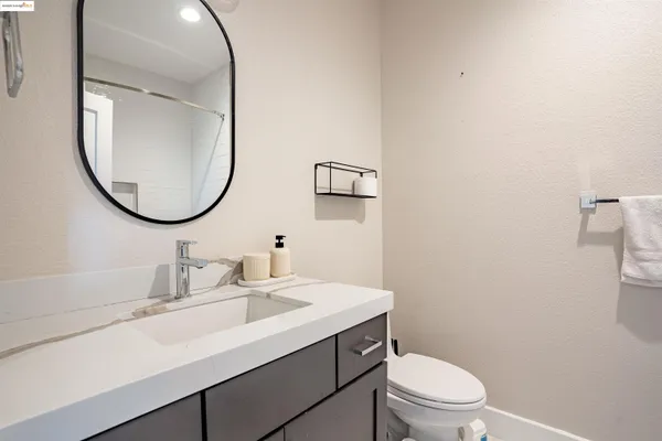 a bathroom with a sink a toilet and mirror