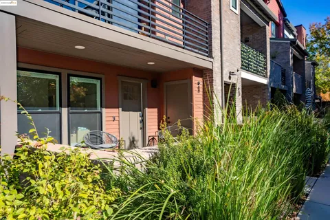 front view of a house with a large window and potted plants