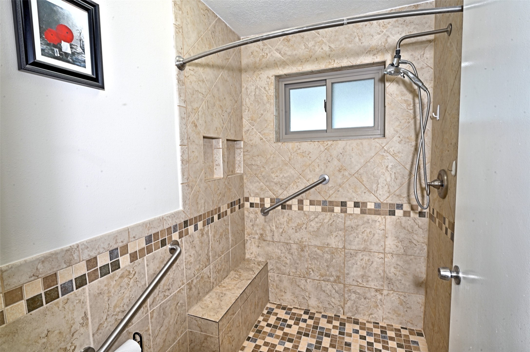 16715 Maplemont Drive Houston, TX 77095 - Photo 14 of 24 Primary Bathroom features a spacious, walk-in shower with tiled walls and floor. It includes a sitting nook and safety grab bars.