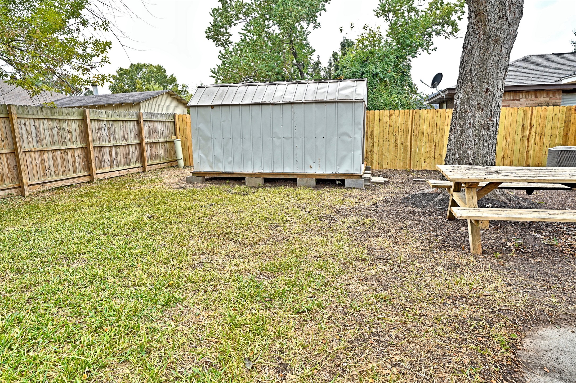 16715 Maplemont Drive Houston, TX 77095 - Photo 20 of 24 Spacious fully - fenced backyard featuring a metal storage shed and a picnic table, ideal for outdoor activities and storage.