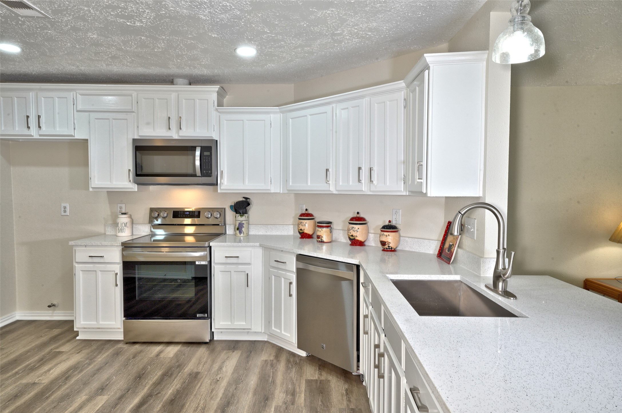 16715 Maplemont Drive Houston, TX 77095 - Photo 7 of 24 Bright, modern kitchen with white cabinetry, stainless steel appliances, and sleek countertops. Features a spacious layout with ample storage and contemporary lighting.
