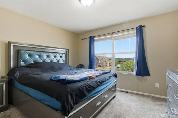 a bed sitting in a bedroom next to a window