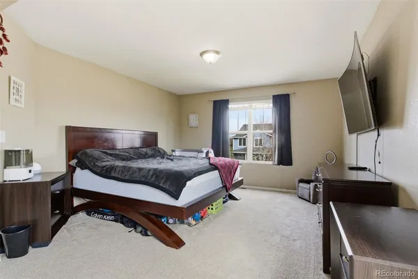 a bedroom with a bed window and a flat screen television
