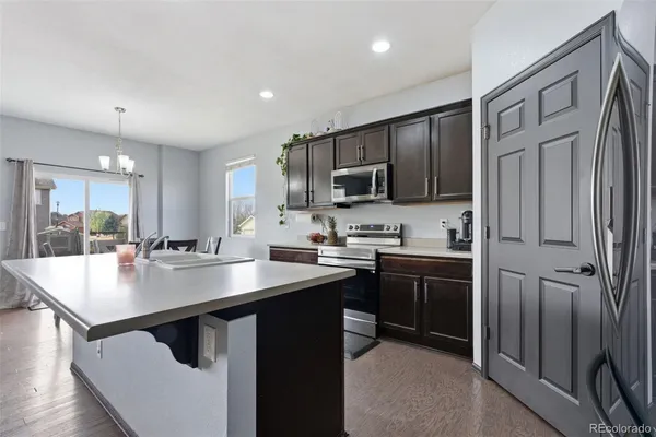 a kitchen with kitchen island a sink stove and refrigerator