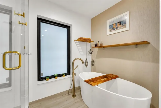 a bathroom with a tub a sink and a mirror