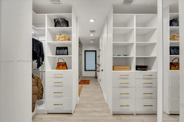 a view of walk in closet with clothes and shoes