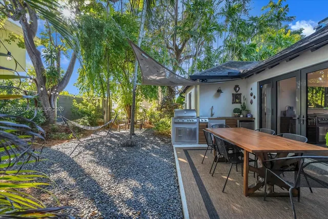 a view of a dinning table and chairs in backyard of the house
