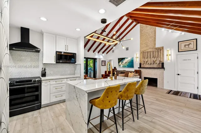 a kitchen with stainless steel appliances kitchen island granite countertop a stove a sink and a microwave