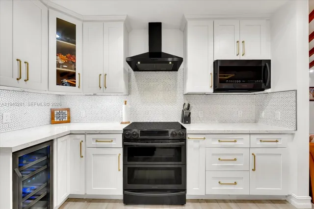 a kitchen with white cabinets and black appliances