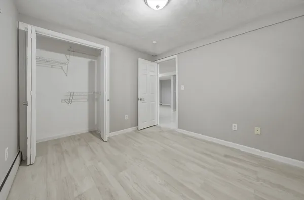 a view of an empty room with wooden floor