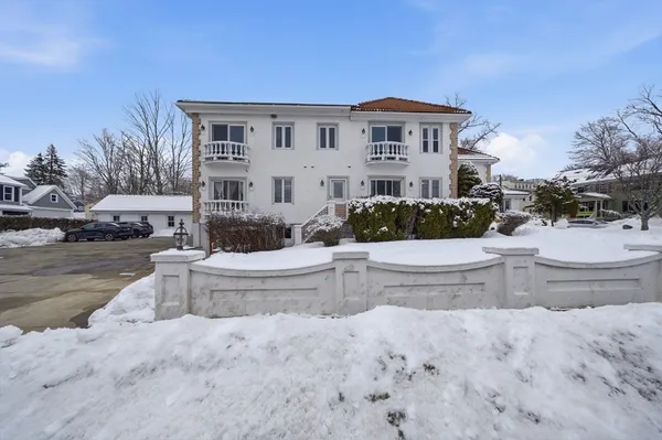a front view of a house with a yard and fountain