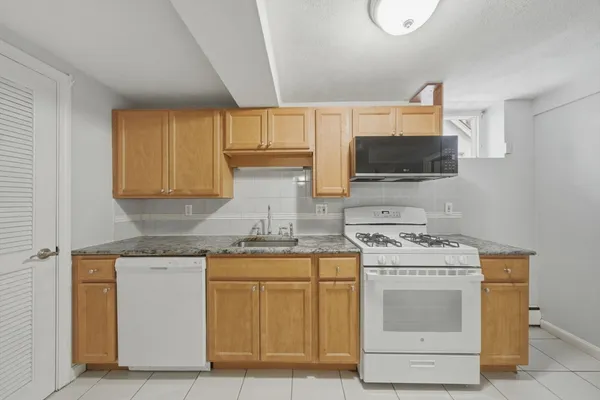 a kitchen with a stove top oven sink and cabinets