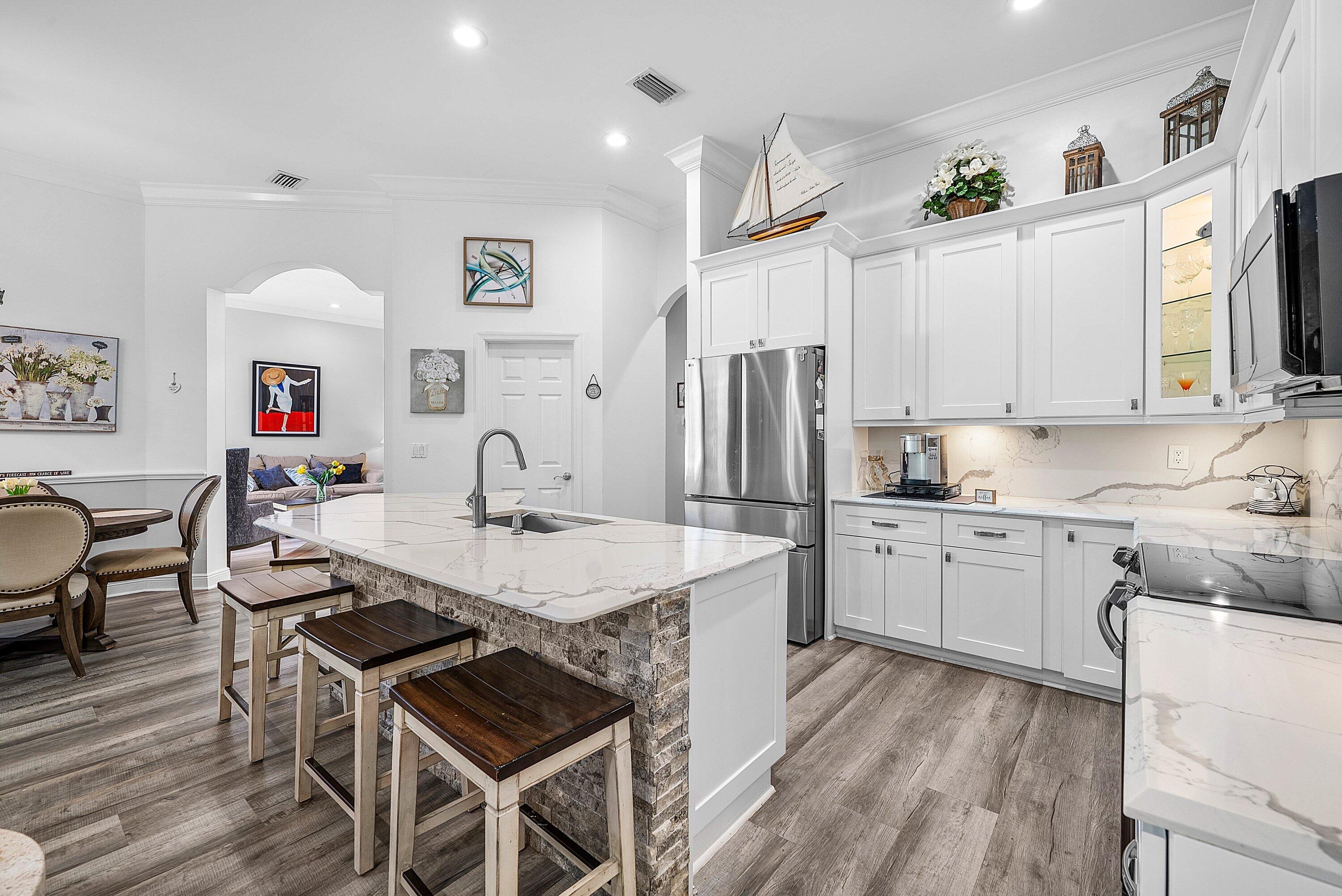 18670 Southeast Lakeside Way Jupiter, FL 33469 - Photo 15 of 56 a kitchen with stainless steel appliances granite countertop a stove a sink dishwasher a refrigerator and white cabinets with wooden floor