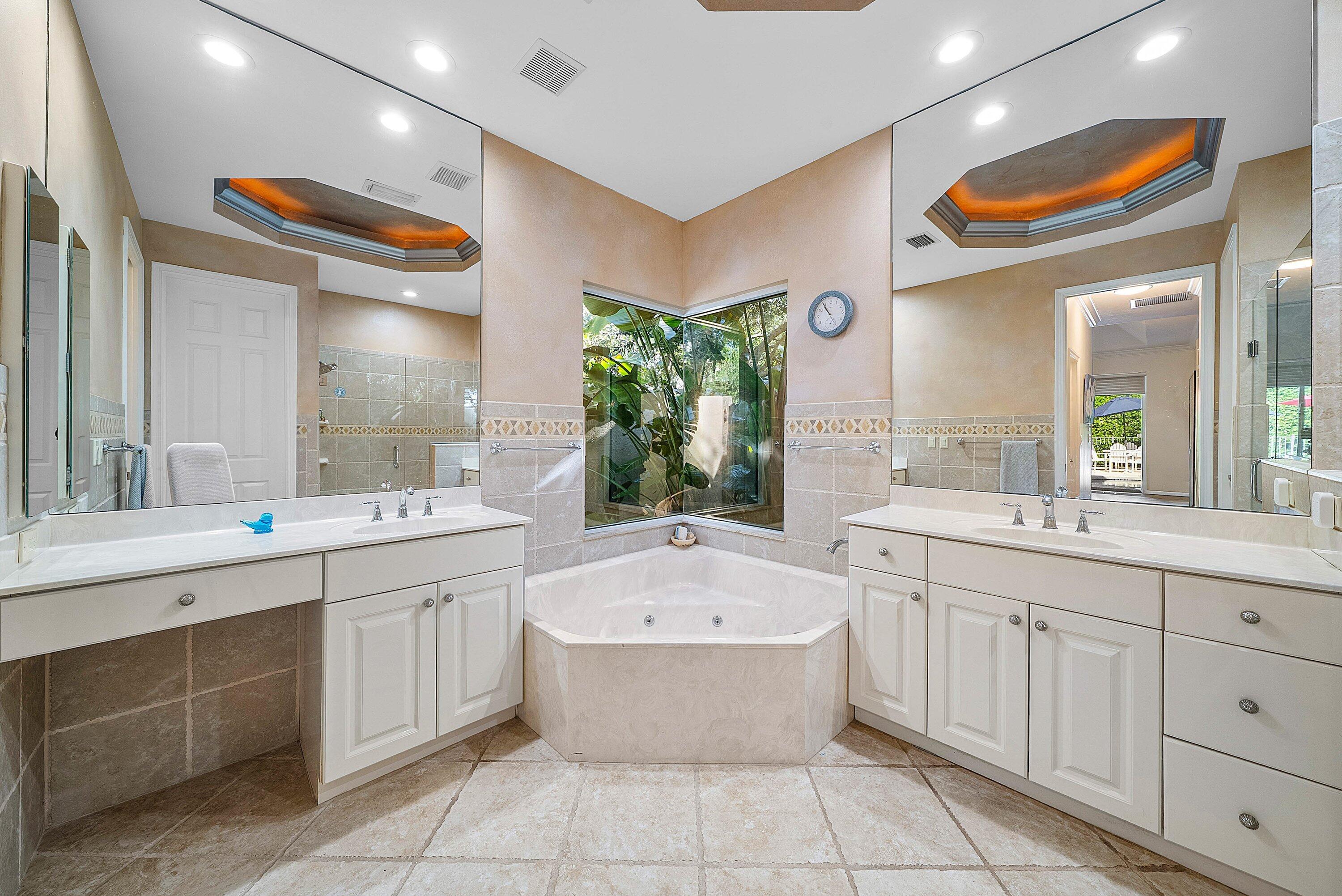 18670 Southeast Lakeside Way Jupiter, FL 33469 - Photo 23 of 56 a bathroom with a tub sink and mirror