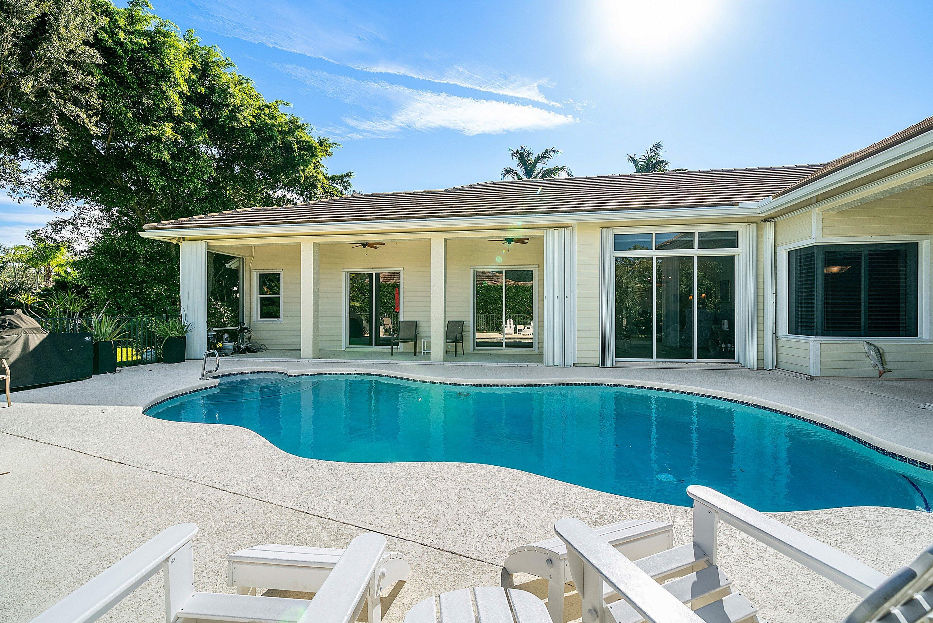 18670 Southeast Lakeside Way Jupiter, FL 33469 - Photo 38 of 56 a view of a house with pool lawn chairs and floor to ceiling window