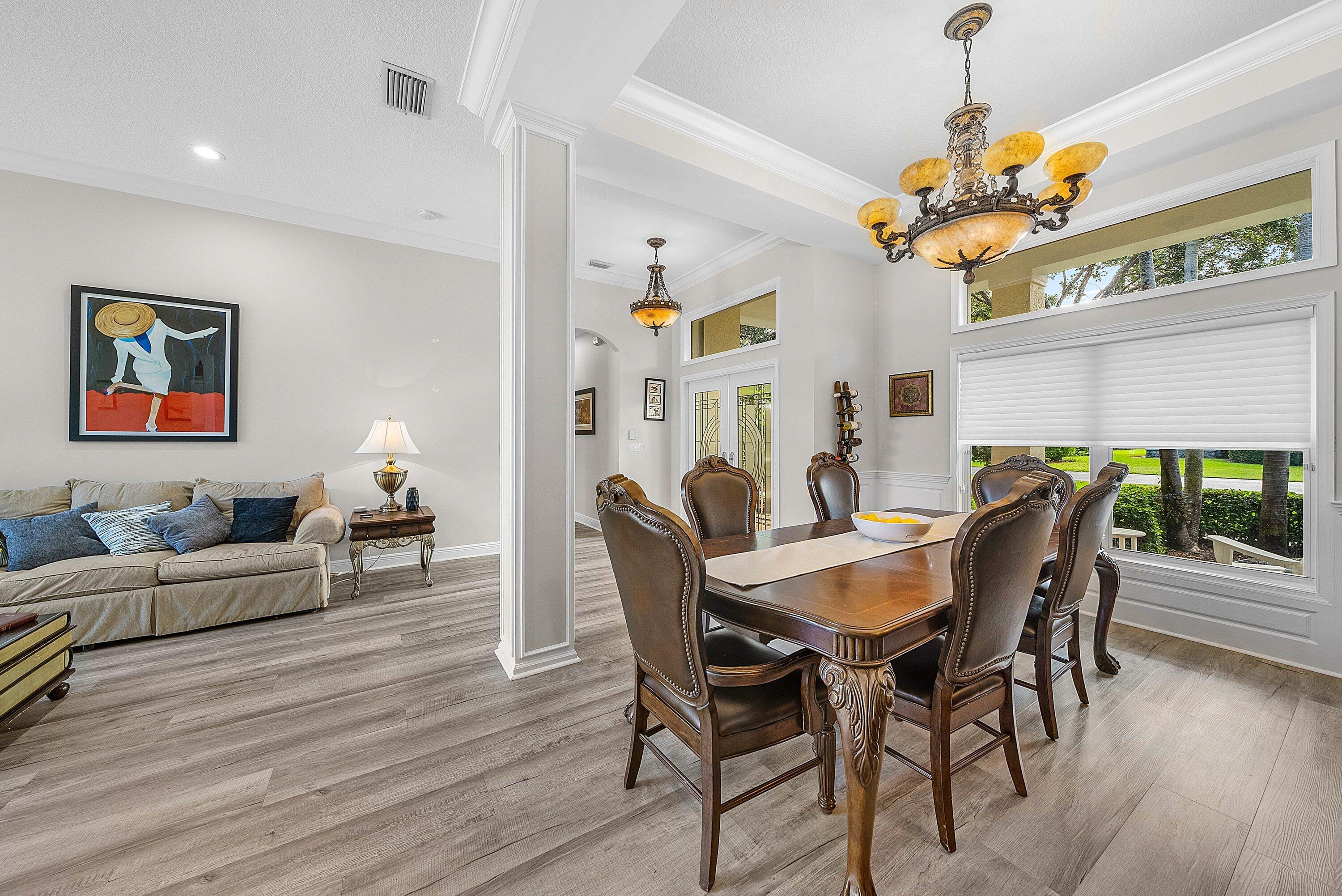 18670 Southeast Lakeside Way Jupiter, FL 33469 - Photo 10 of 56 a view of a dining room with furniture wooden floor and chandelier