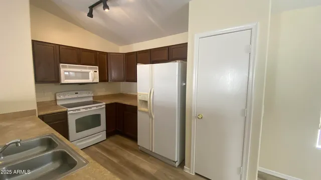 a kitchen with stainless steel appliances granite countertop a refrigerator and a stove