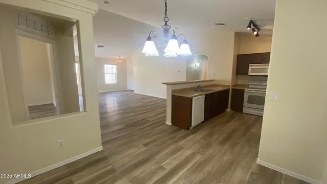 a kitchen with stainless steel appliances granite countertop a stove and a wooden floors
