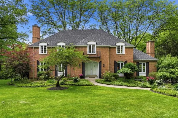 a front view of a house with a yard and trees