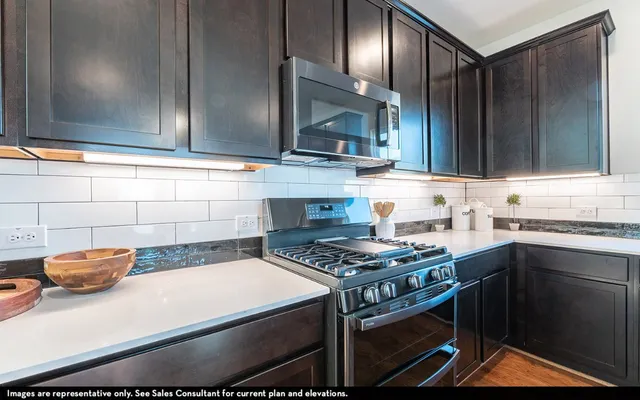 a kitchen with stainless steel appliances granite countertop a sink stove and cabinets