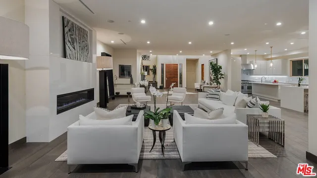 a living room with furniture a couch and a view of kitchen
