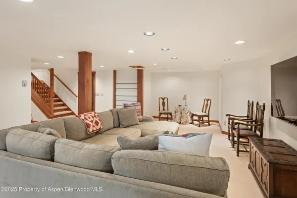 a living room with furniture kitchen view and a wooden floor