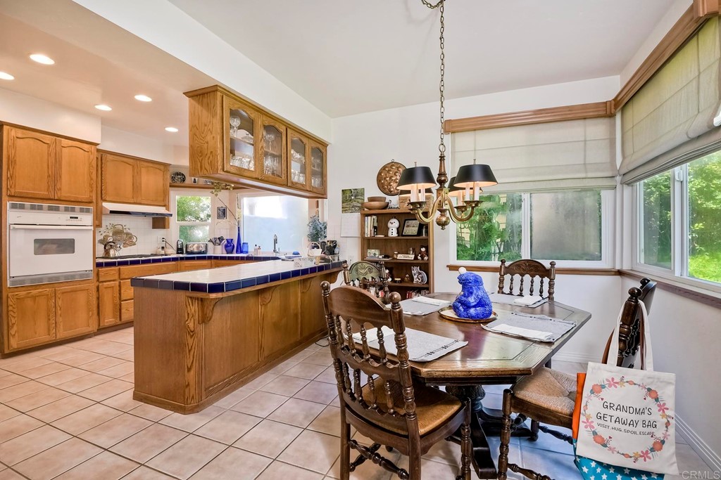 2270 Valley Road Oceanside, CA 92056 - Photo 11 of 37 a dining room with stainless steel appliances kitchen island granite countertop a table chairs and a wooden cabinets