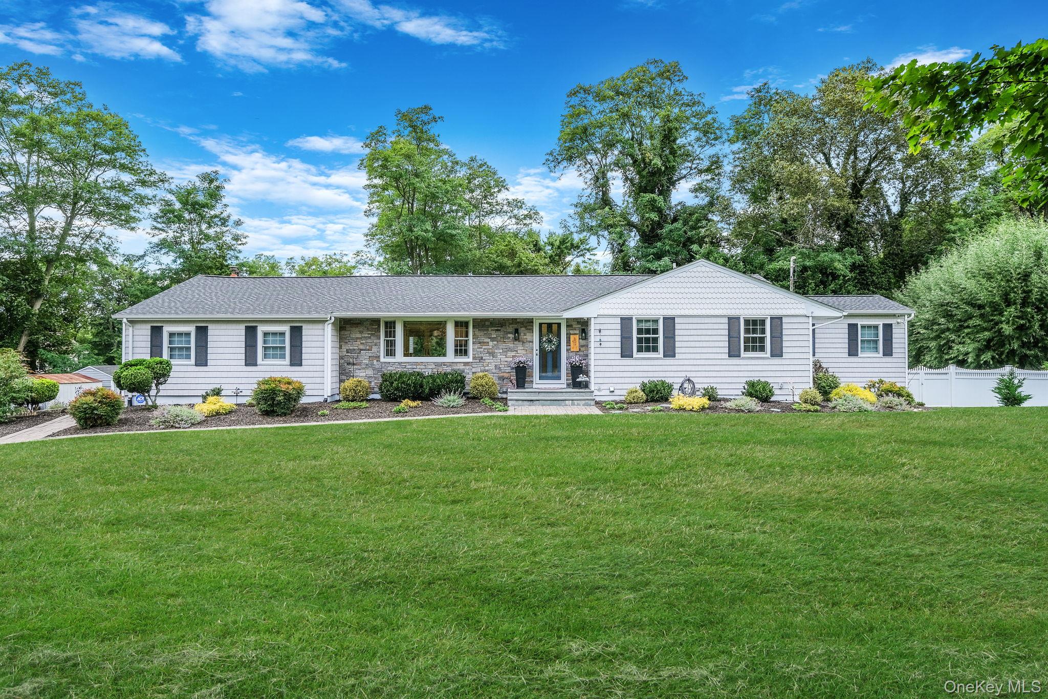 Ranch-style house with covered porch and stone siding