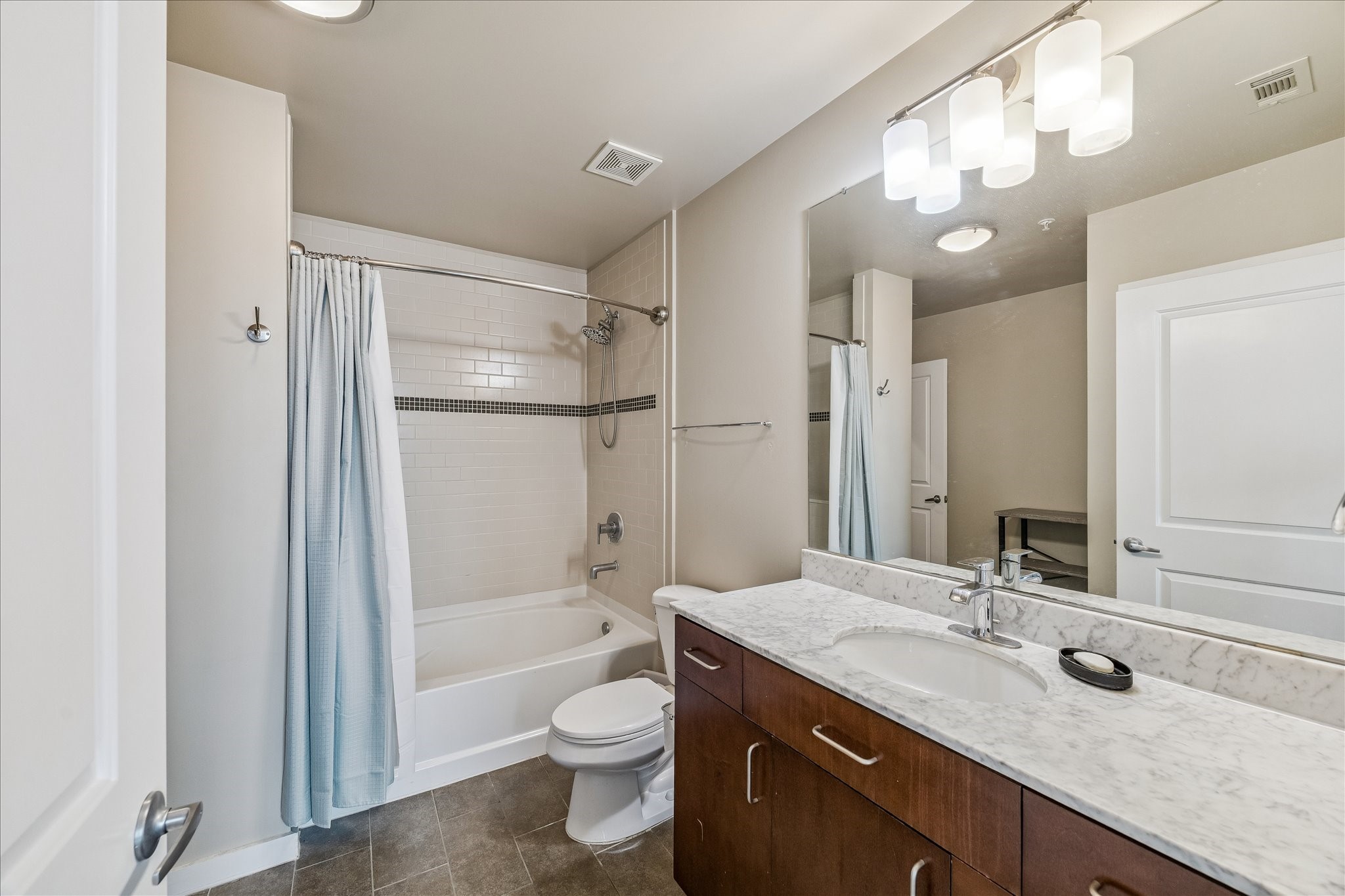 5925 Almeda Road, Unit 12704 Houston, TX 77004 - Photo 8 of 31 The stylish bathroom features a large vanity with stone countertops, contemporary cabinetry, and a spacious tub/shower combination. Clean lines and quality finishes provide a spa-inspired feel.