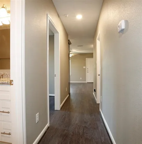 a view of a hallway with wooden floor