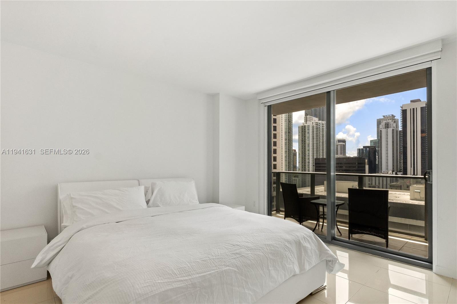 31 Southeast 6th Street, Unit 2007 Miami, FL 33131 - Photo 11 of 22 a bedroom with a bed table and mirror