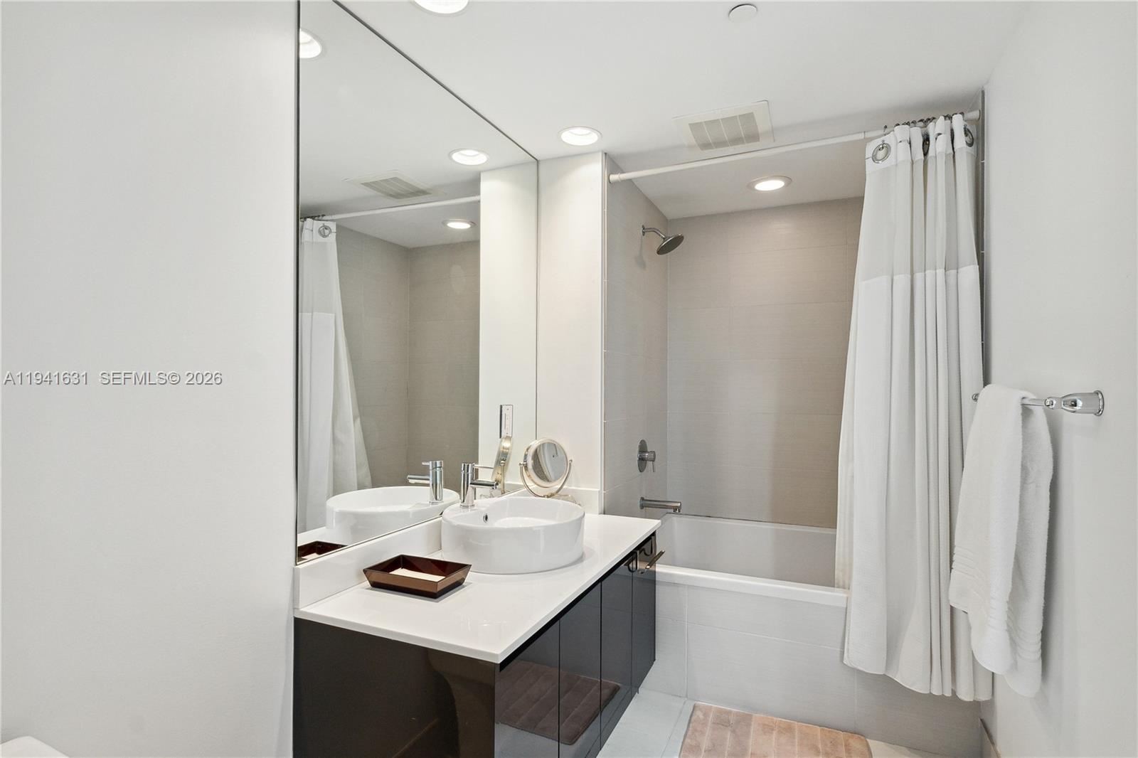 31 Southeast 6th Street, Unit 2007 Miami, FL 33131 - Photo 13 of 22 a bathroom with a sink a bathtub and a mirror