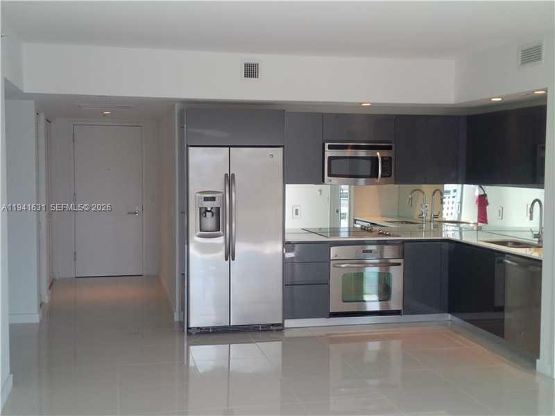 31 Southeast 6th Street, Unit 2007 Miami, FL 33131 - Photo 19 of 22 a kitchen with stainless steel appliances granite countertop a refrigerator and a stove