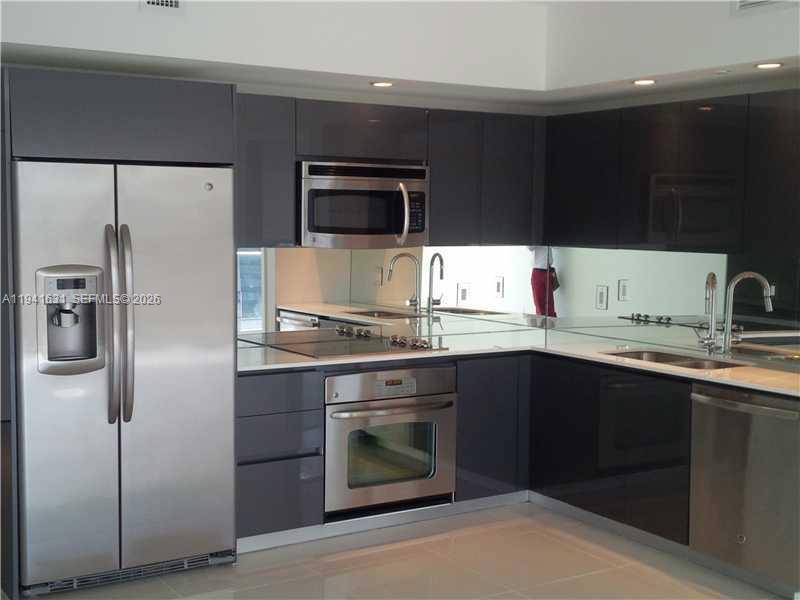 31 Southeast 6th Street, Unit 2007 Miami, FL 33131 - Photo 20 of 22 a kitchen with stainless steel appliances a sink stove and refrigerator