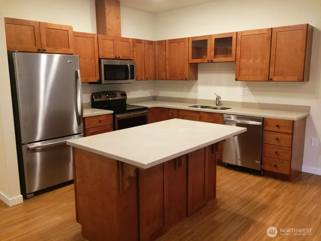 a kitchen with stainless steel appliances a microwave a sink and a refrigerator