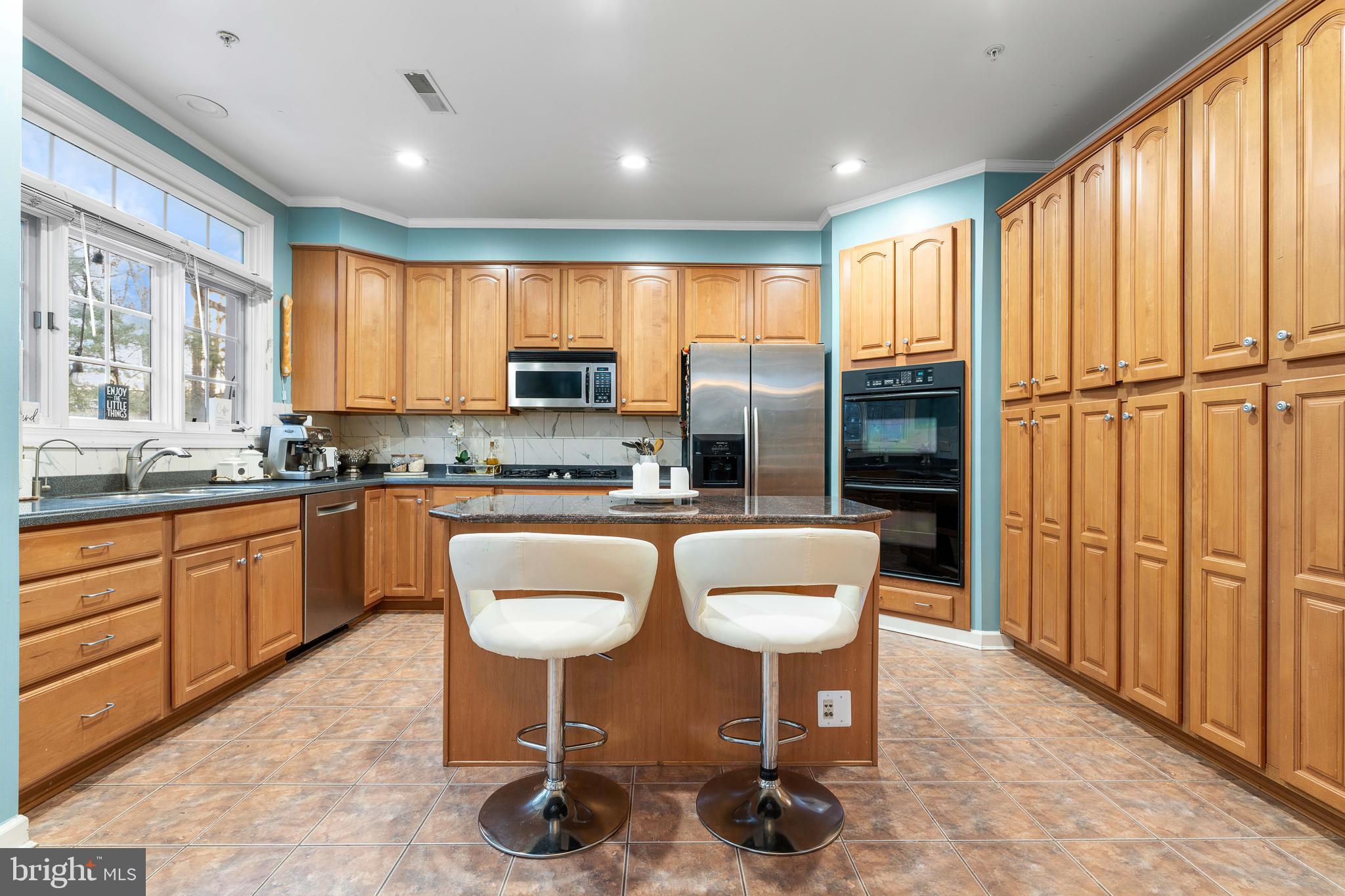12461 Rose Path Circle Fairfax, VA 22033 - Photo 14 of 43 a kitchen with stainless steel appliances granite countertop a stove a sink a dining table and chairs